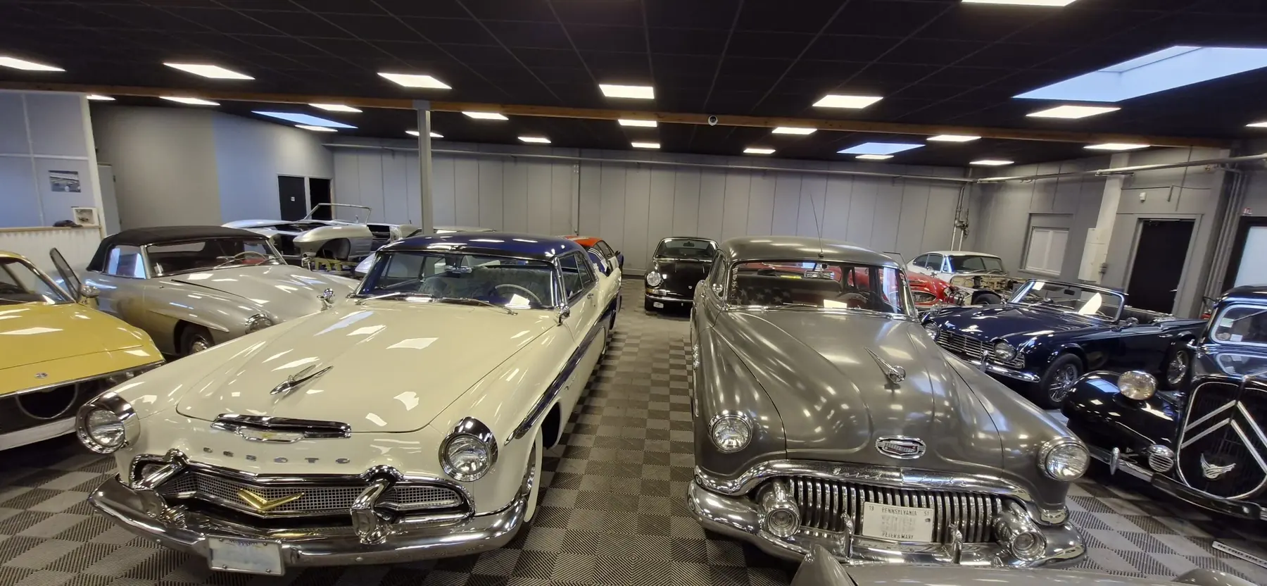 DeSoto et Buick anciennes aux chromes brillants dans le hall de l'atelier